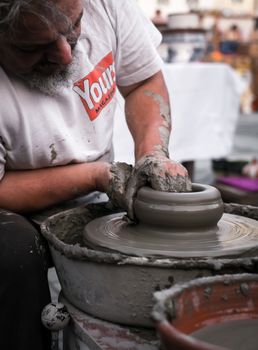 Sibiu City, Romania - 31 August 2019. Hands of a potter shaping a clay pot on a potter's wheel at the potters fair from Sibiu, Romania