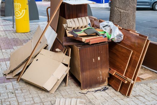 Malaga, Spain - May 20, 2018. Home furniture thrown in the the street in the city polluting the town and environment