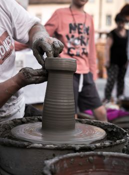 Sibiu City, Romania - 31 August 2019. Hands of a potter shaping a clay pot on a potter's wheel at the potters fair from Sibiu, Romania