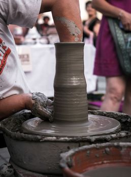 Sibiu City, Romania - 31 August 2019. Hands of a potter shaping a clay pot on a potter's wheel at the potters fair from Sibiu, Romania