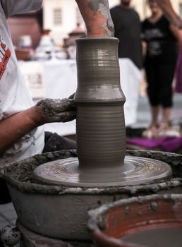 Sibiu City, Romania - 31 August 2019. Hands of a potter shaping a clay pot on a potter's wheel at the potters fair from Sibiu, Romania