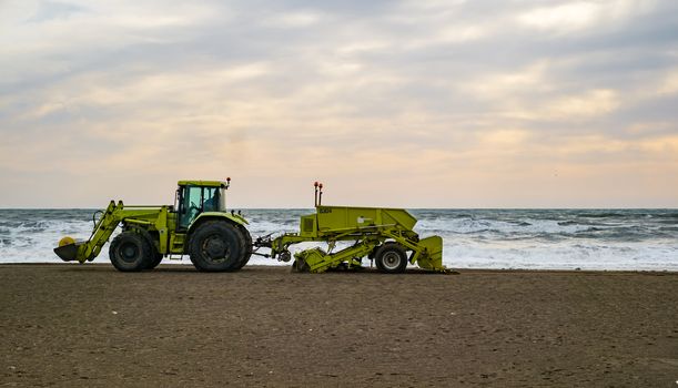 Malaga, Spain - January 29, 2018. Tractor on the sandy beach cleaning
