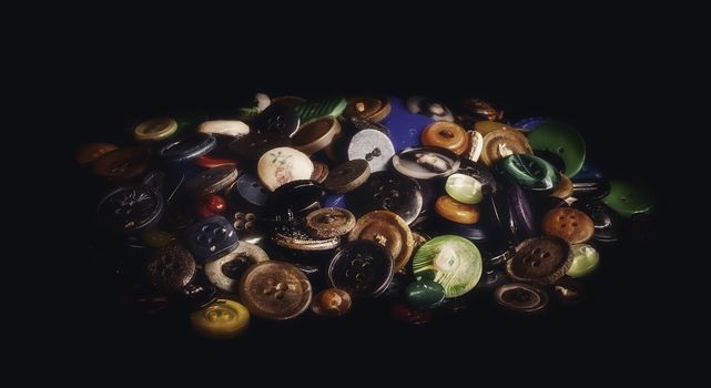 A bunch of old buttons on black background