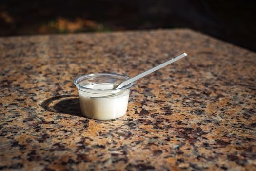 a cup of ice cream in the sun on the marble bench