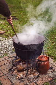 A Country Woman Preparing a Romanian Traditional Food at the Cauldron