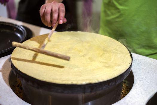 A person making pancakes in a kitchen