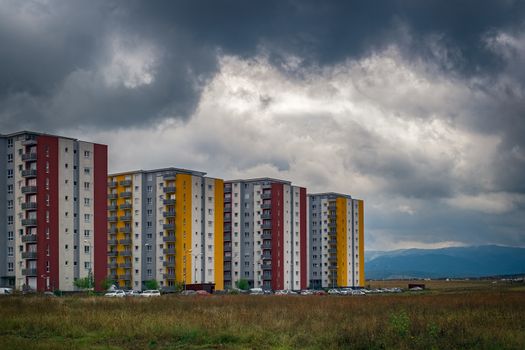 apartment blocks with cars in parking with cloudy sky in Sibiu city, Romania