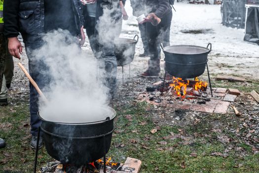 an unknown person prepares a traditional Romanian food prepared at the cauldron on the open fire, Christmas tradition