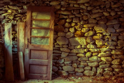 an old wooden door resting inside an old stone house