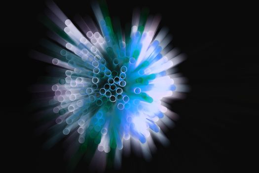 colored plastic drinking straws on black background