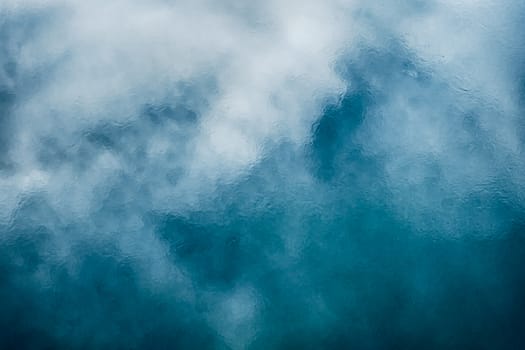 cloudy sky reflected on frozen lake top view