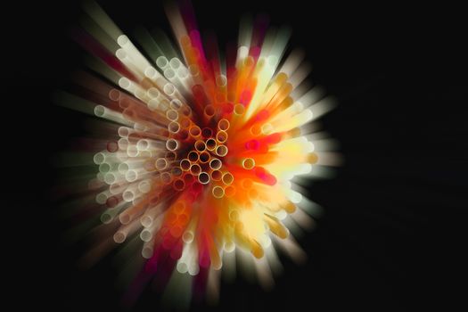 colored plastic drinking straws on black background