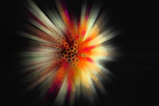 colored plastic drinking straws on black background