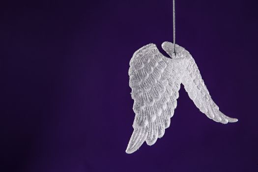 Purple Christmas background concepts with white hearts and wings with copy space