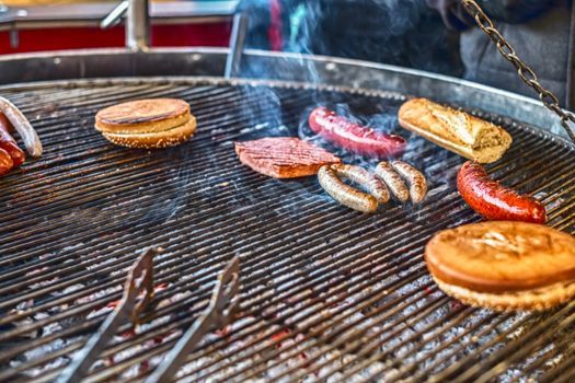 hamburger and sausages on the grill with smoke