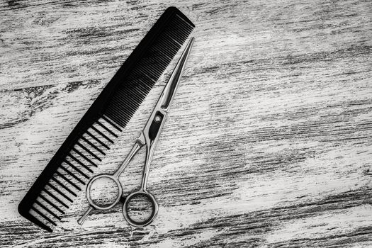 hair cutting scissor for hairdressers and comb in beauty salon on wooden background