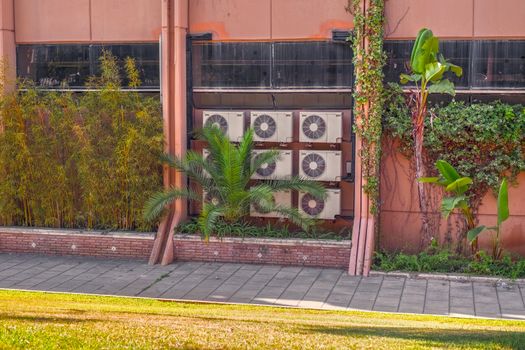 industrial air conditioner on building with palms and flowers in Marbella, Spain