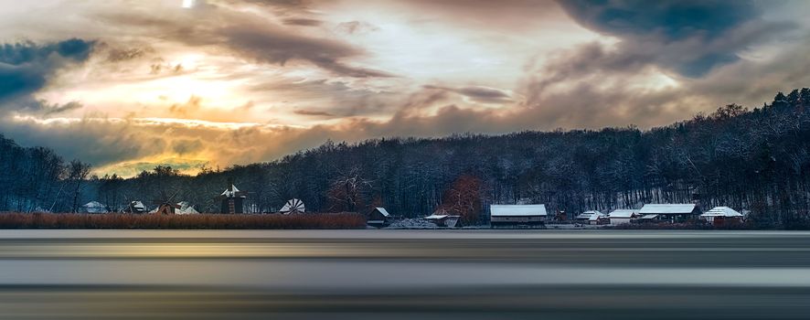 Winter panorama with windmills. Dumbrava lake, Astra Museum of Traditional Folk Civilization, Sibiu city, Romania