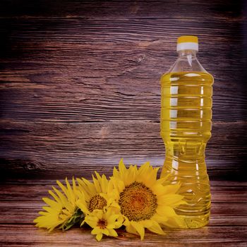 Sunflower oil with flowers on rustic wooden background. Studio shot.