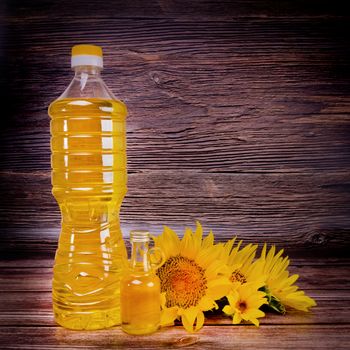 Sunflower oil with flowers on rustic wooden background. Studio shot.