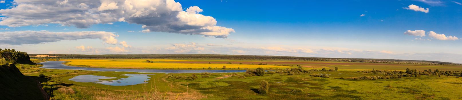 Summer landscape with river and cloudy sky, panorama