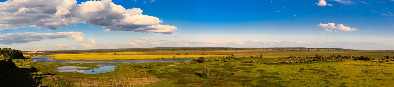 Summer landscape with river and cloudy sky, panorama