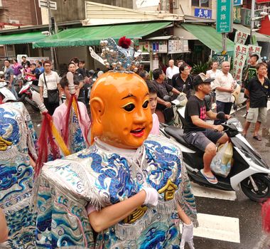 KAOHSIUNG, TAIWAN -- JULY 9, 2016: Male dancers with head covering masks perform during a traditional religious temple ceremony.