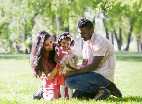 A South Asian happy young family is walking in city park