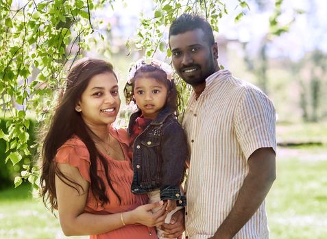 Happy young couple with a little daughter in the Park