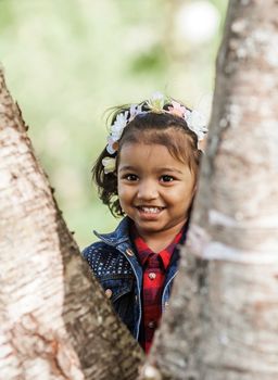 A smiling little girl is playing in park