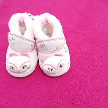 Baby shoes placed beautifully in pink background