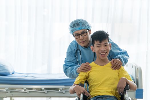 Asian Volunteer Doctors Caring and Helping Rehabilitation of Disabled Boys Stay at the hospital. The boy is crippled, Asian people can't help themselves. Must sit in a wheelchair all the time