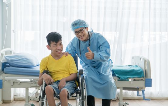 Asian Volunteer Doctors Caring and Helping Rehabilitation of Disabled Boys Stay at the hospital. The boy is crippled, Asian people can't help themselves. Must sit in a wheelchair all the time