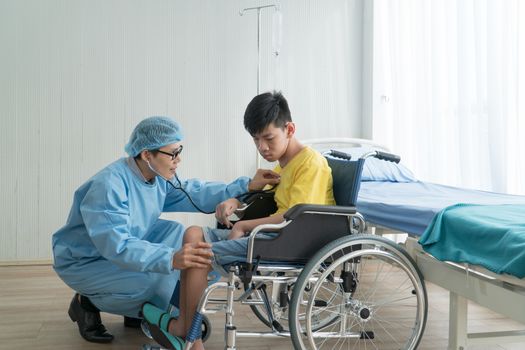 Asian Volunteer Doctors Caring and Helping Rehabilitation of Disabled Boys Stay at the hospital. The boy is crippled, Asian people can't help themselves. Must sit in a wheelchair all the time