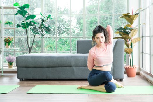 Attractive and healthy woman Asian are exercising Stretching with yoga postures at home helps to balance life. copy space is on the right side of the image For adding text