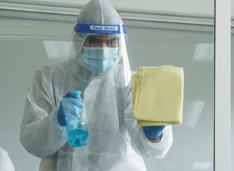 Workers wear protective clothing and wear a mask. Spraying disinfectants for cleaning inside the building. Cleaning service professionals are becoming popular After the spread of coronavirus