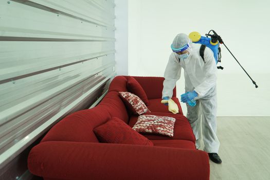 Workers wear protective clothing and wear a mask. Spraying disinfectants for cleaning inside the building. Cleaning service professionals are becoming popular After the spread of coronavirus