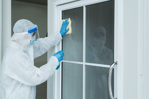 Workers wear protective clothing and wear a mask. Spraying disinfectants for cleaning inside the building. Cleaning service professionals are becoming popular After the spread of coronavirus