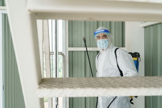 Workers wear protective clothing and wear a mask. Spraying disinfectants for cleaning inside the building. Cleaning service professionals are becoming popular After the spread of coronavirus