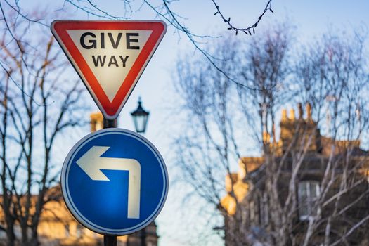 A give way sign and left turn road sign in England