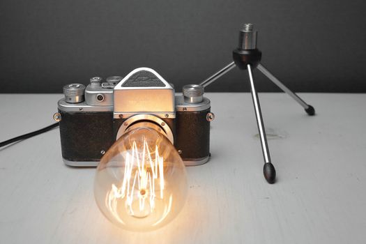 Retro lamp from an old camera with an Edison lamp on a gray background. Concept is a good idea. High quality photo