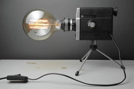 Retro lamp from an old camera with an Edison lamp on a gray background. Concept is a good idea. High quality photo