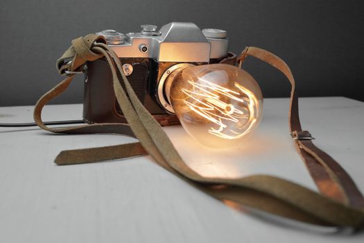 Retro lamp from an old camera with an Edison lamp on a gray background. Concept is a good idea. High quality photo