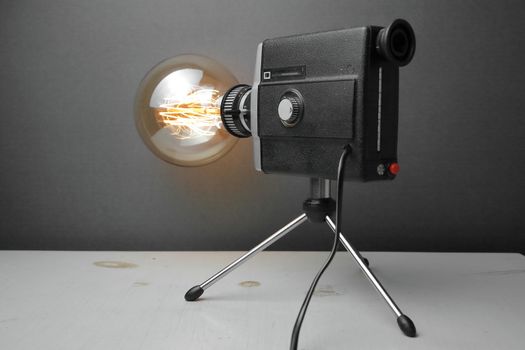 Retro lamp from an old camera with an Edison lamp on a gray background. Concept is a good idea. High quality photo