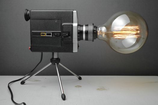 Retro lamp from an old camera with an Edison lamp on a gray background. Concept is a good idea. High quality photo