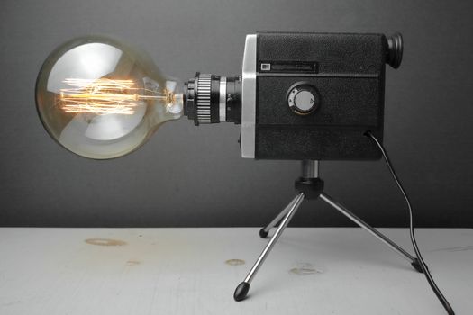 Retro lamp from an old camera with an Edison lamp on a gray background. Concept is a good idea. High quality photo