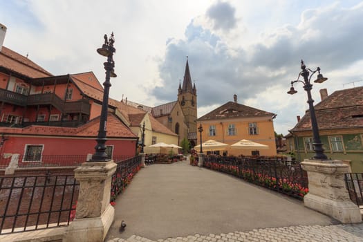 SIBIU, ROMANIA - Circa 2020: Old medieval town brick wall with cloudy blue sky. Beautiful tourist spot in eastern central Europe. Famous bridge of lies in Sibiu Romania