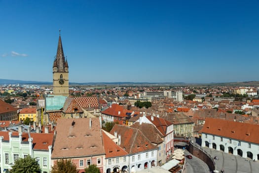 SIBIU, ROMANIA - Circa 2020: High view of old medieval town with cloudy blue sky. Beautiful tourist spot in eastern central Europe. Aerial view of famous Evangelic Church in Sibiu Romania