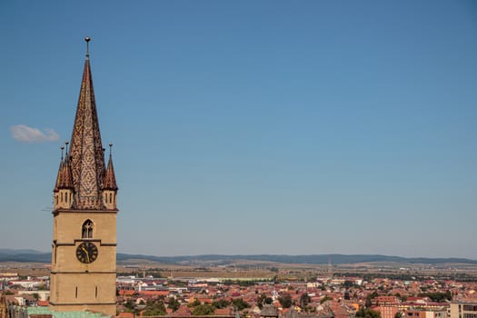 SIBIU, ROMANIA - Circa 2020: High view of old medieval town with cloudy blue sky. Beautiful tourist spot in eastern central Europe. Aerial view of famous Evangelic Church in Sibiu Romania