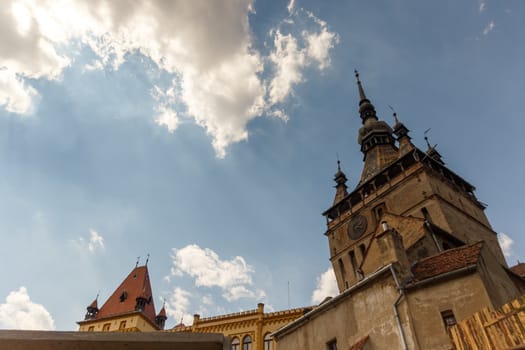 SIGHISOARA, ROMANIA - Circa 2020: Old medieval town with cloudy blue sky. Beautiful tourist spot in eastern central Europe. Famous old medieval Clock Tower in Sighisoara Romania